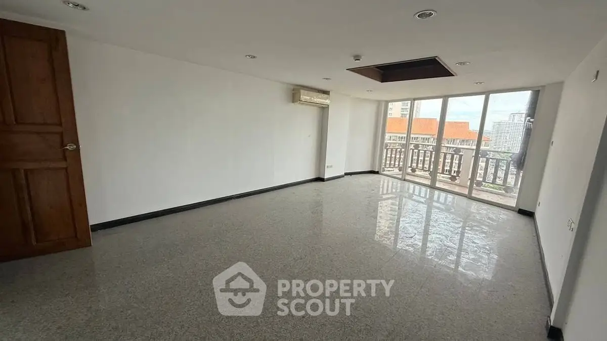 Spacious empty living room with large windows and city view