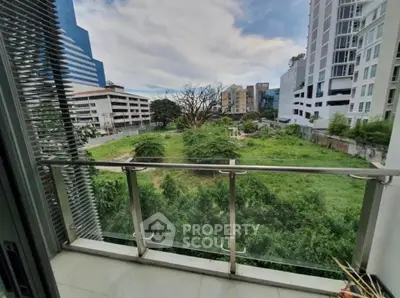 Spacious balcony with lush green view in urban setting