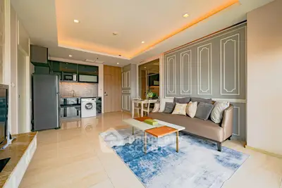 Modern living room with open kitchen, stylish decor, and washing machine.