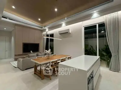 Modern open-plan living and dining area with sleek design and natural lighting.