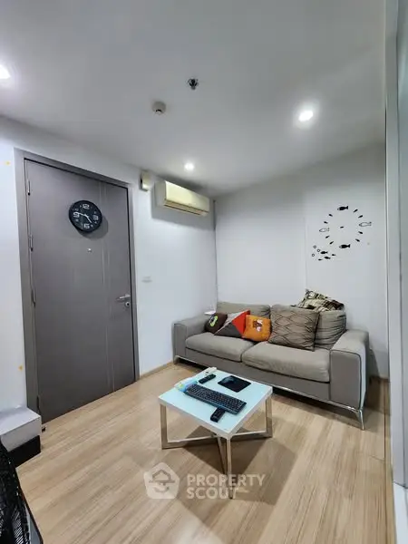 Modern living room with stylish sofa and wall clock, perfect for cozy relaxation.