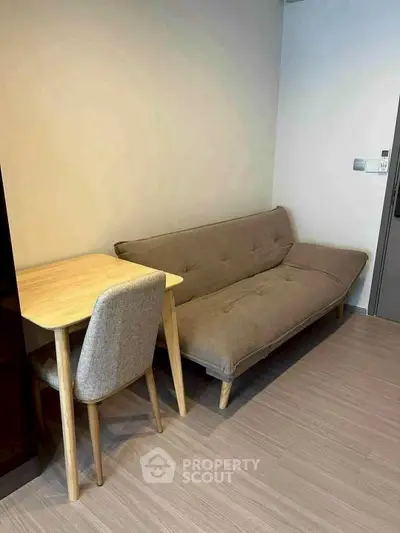 Cozy living room with modern sofa and wooden table, perfect for compact spaces.