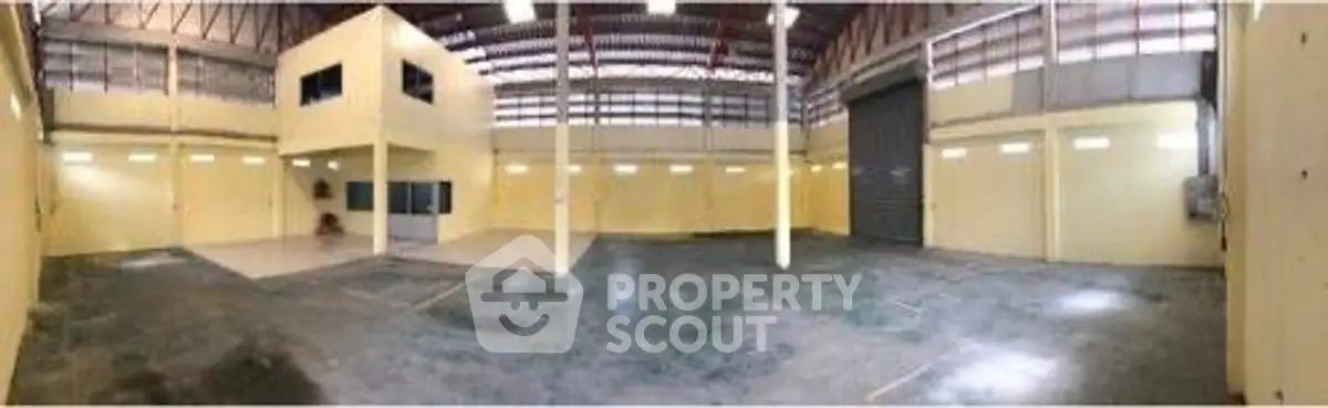 Spacious industrial warehouse with high ceilings and ample natural light.