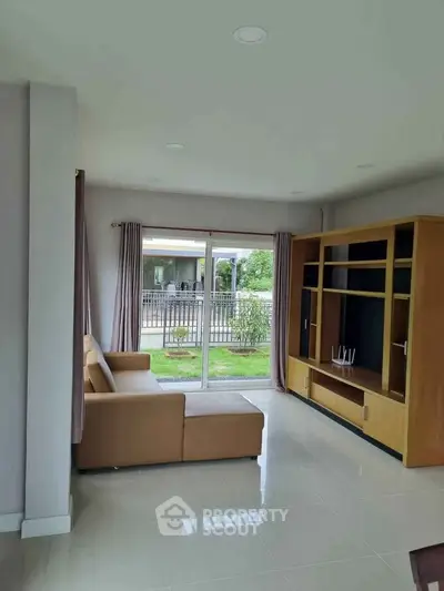 Spacious living room with modern furniture and garden view, perfect for family gatherings.
