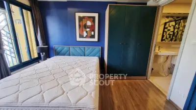 Modern bedroom with stylish decor and ensuite bathroom in vibrant apartment.