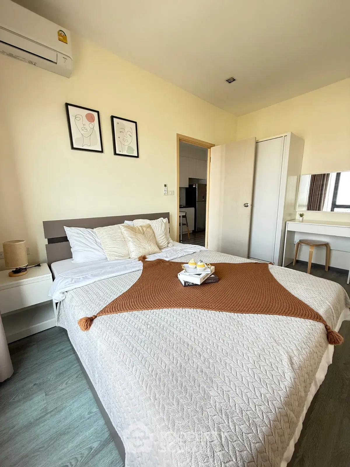 Cozy bedroom with modern decor and natural light, featuring a comfortable bed and stylish artwork.