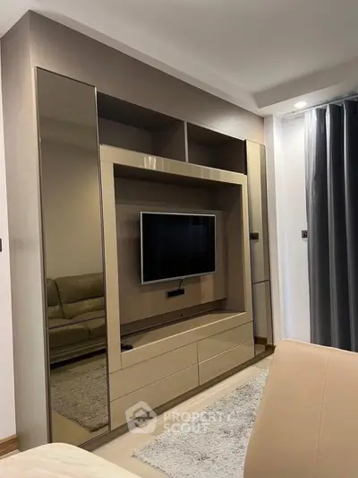 Modern living room with sleek entertainment center and cozy seating area.