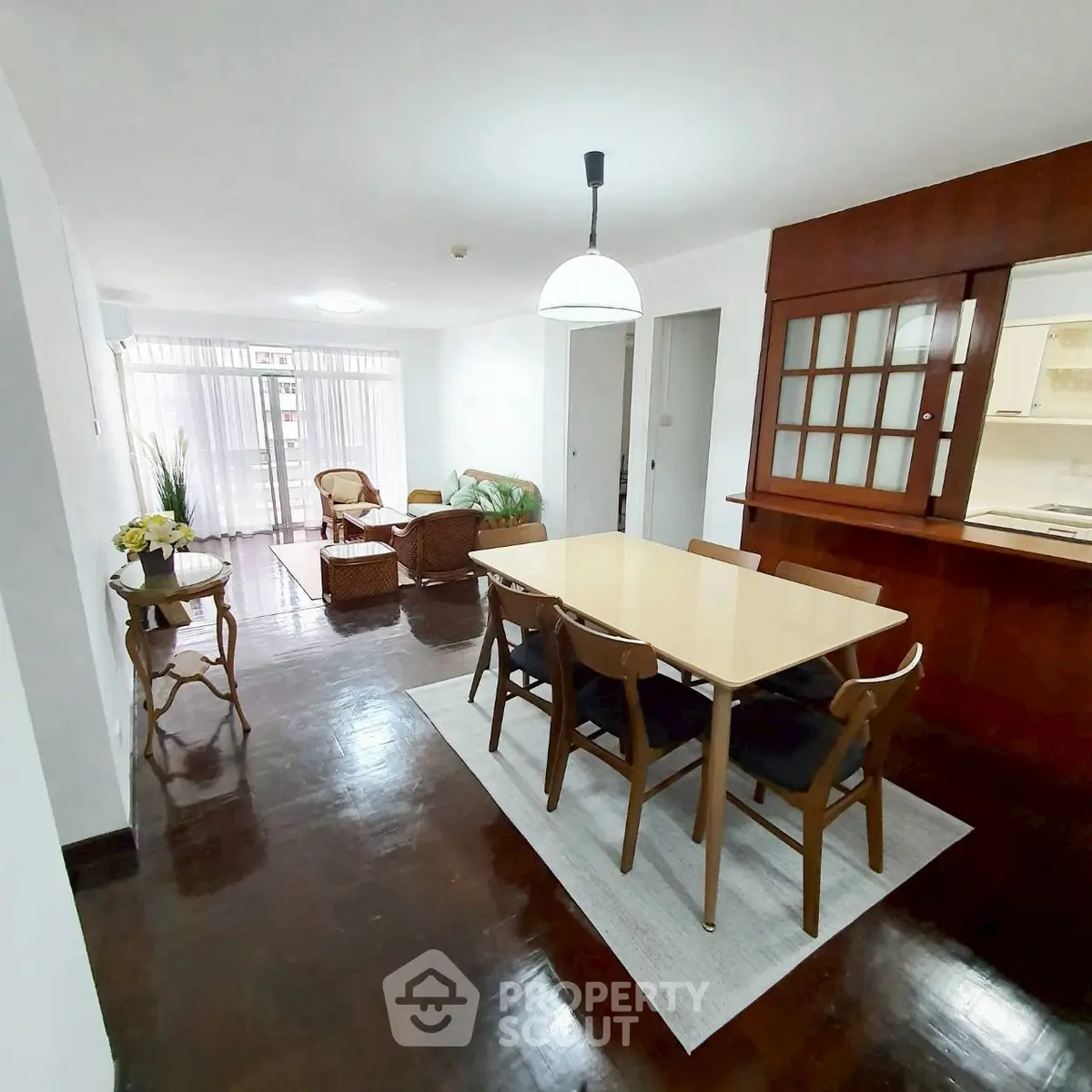 Spacious open-plan living and dining area with elegant wooden flooring and modern furnishings.