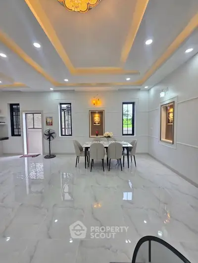 Elegant dining area with modern lighting and marble flooring in a spacious open layout.