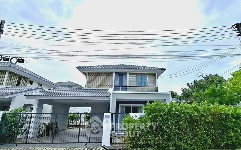 Charming two-story house with lush greenery and modern design in serene neighborhood.