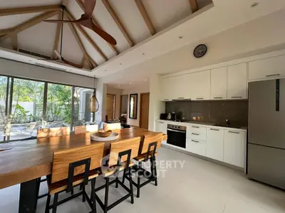 Spacious modern kitchen with open layout and wooden dining table, perfect for entertaining.