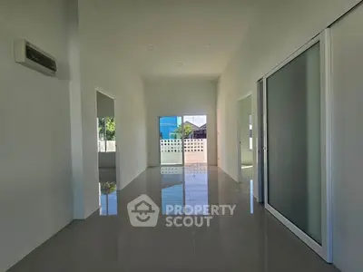 Spacious modern interior with sleek tile flooring and sliding glass doors, perfect for customization.