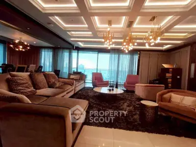 Luxurious living room with modern lighting and plush seating in high-rise apartment.