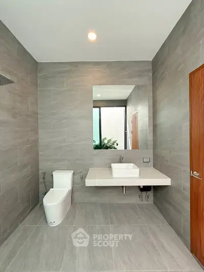 Modern bathroom with sleek gray tiles and minimalist fixtures