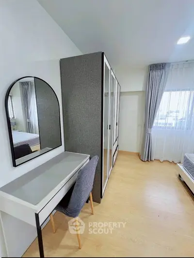 Modern bedroom with stylish furniture and large window for natural light.