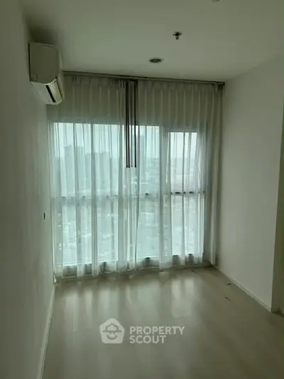 Bright empty room with large windows and sheer curtains, perfect for customization.