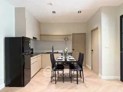 Modern kitchen with sleek dining area and black appliances in stylish apartment