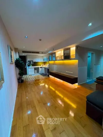 Spacious modern living room with wooden flooring and stylish kitchen area