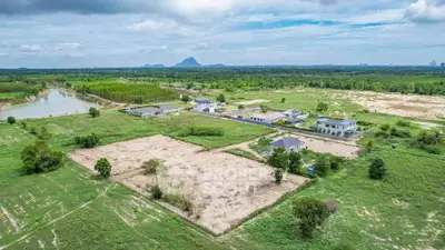 Expansive aerial view of serene countryside with modern homes and lush greenery.