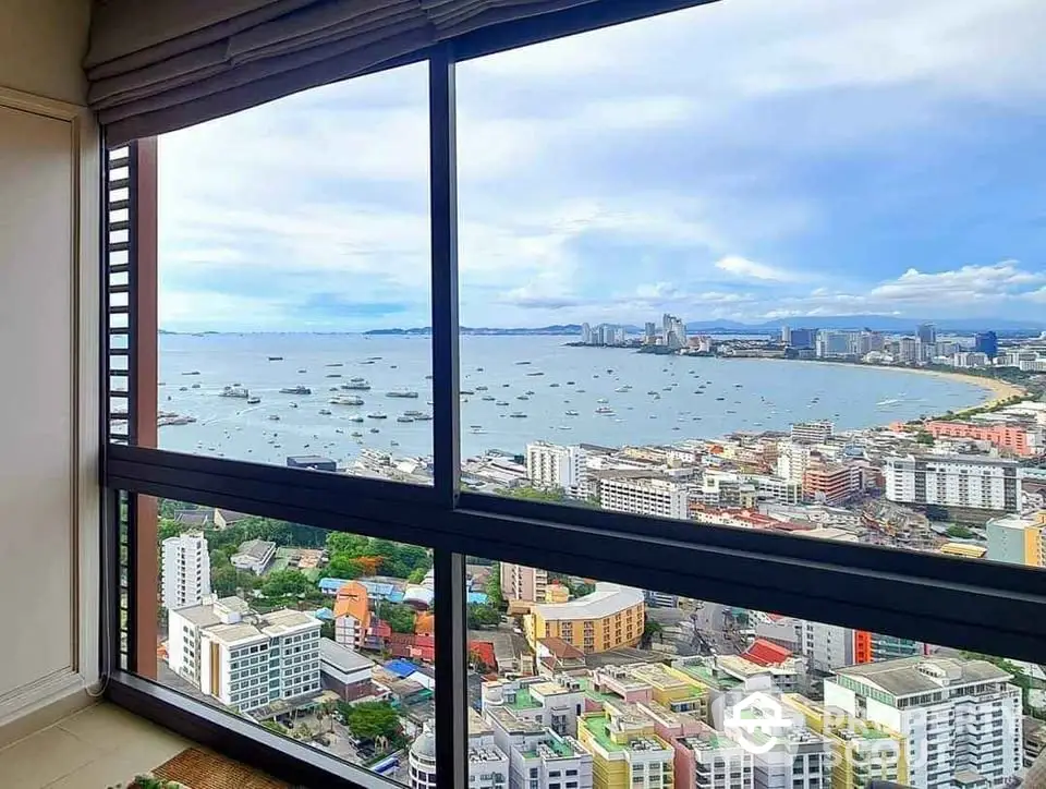 Stunning high-rise apartment view overlooking vibrant cityscape and ocean horizon.