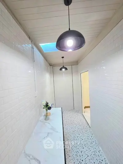 Sleek modern bathroom with terrazzo flooring and pendant lighting