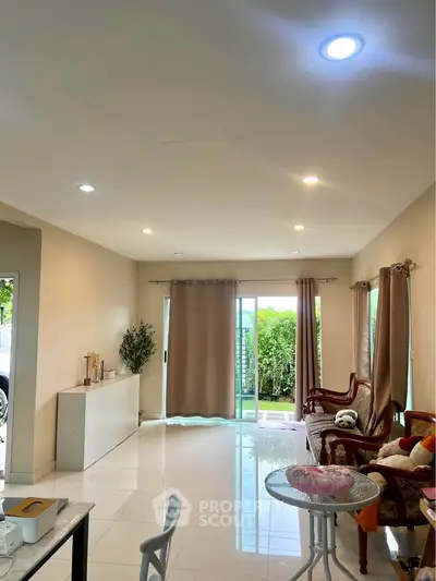 Spacious living room with elegant furniture and garden view, perfect for family gatherings.