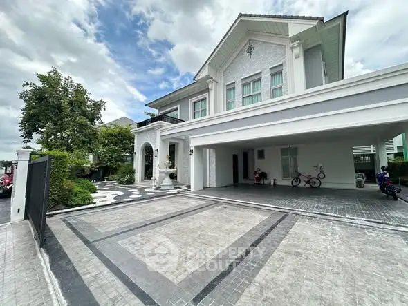 Luxurious modern house with spacious driveway and elegant facade, perfect for upscale living.