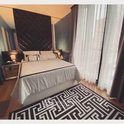 Luxurious bedroom with elegant decor and floor-to-ceiling windows offering city views.