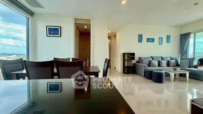 Spacious modern living room with panoramic city views and elegant furnishings.