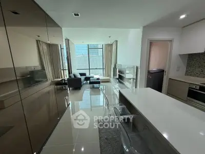 Modern open-plan living room with sleek kitchen and city view, featuring glossy floors and contemporary furniture.