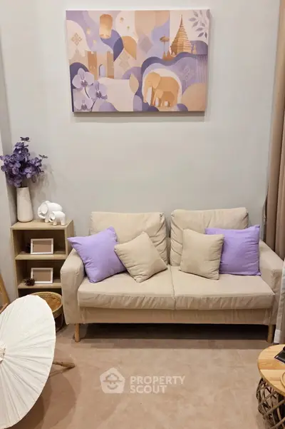 Cozy living room with beige sofa, purple cushions, and elegant wall art, perfect for relaxation.