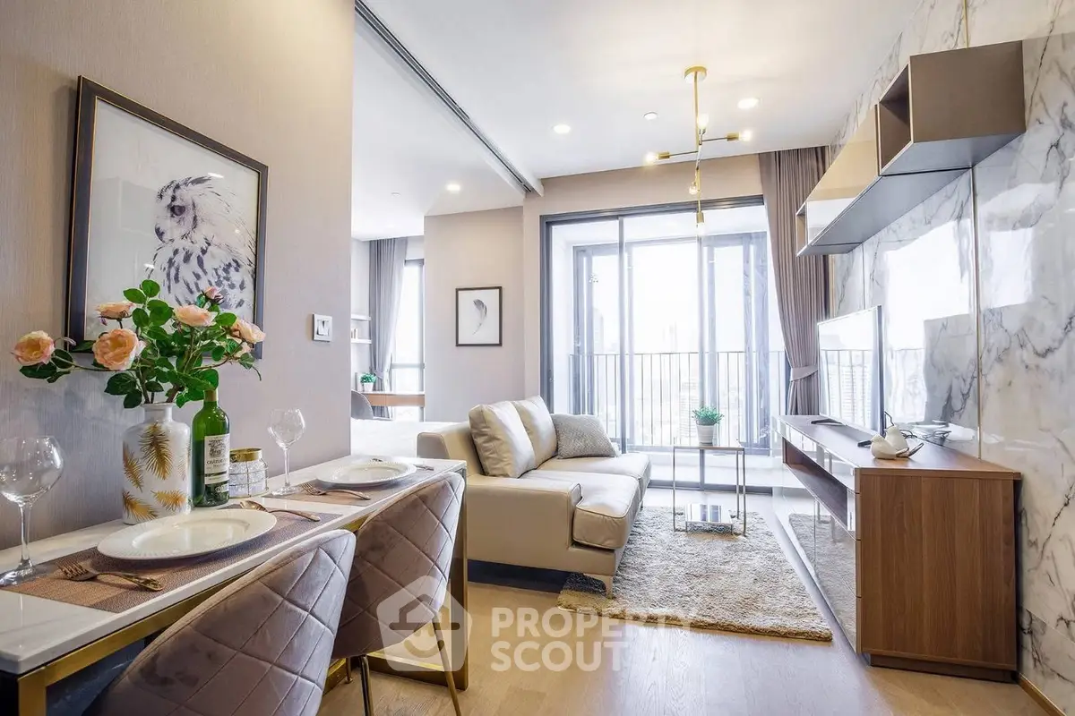 Modern living room with elegant decor and large windows leading to a balcony, featuring stylish furniture and artwork.