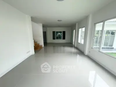 Spacious modern living room with large windows and glossy tiled floors