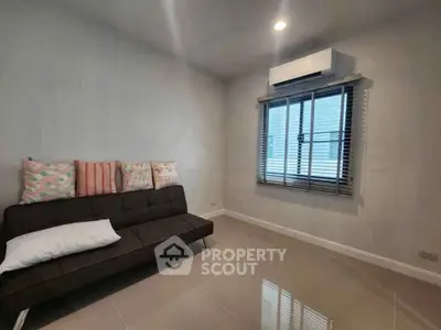 Cozy living room with modern sofa and window, perfect for relaxation.