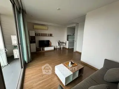 Spacious modern living room with wooden flooring and balcony access