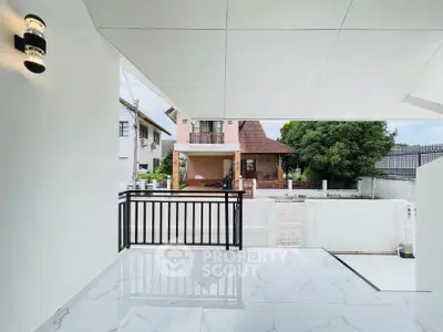 Modern balcony with sleek railing and marble flooring overlooking suburban homes.