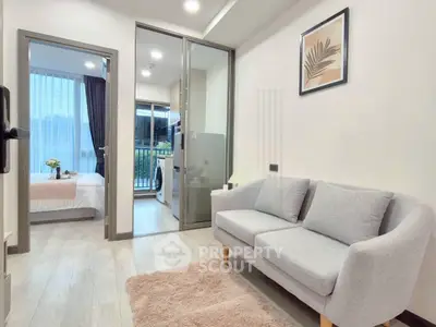 Modern apartment interior with cozy living room and view into bedroom, featuring stylish decor and natural light.