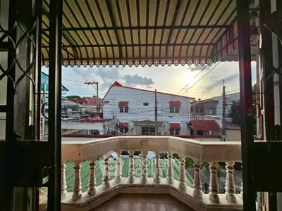 Charming balcony view with classic railing overlooking urban neighborhood at sunset.