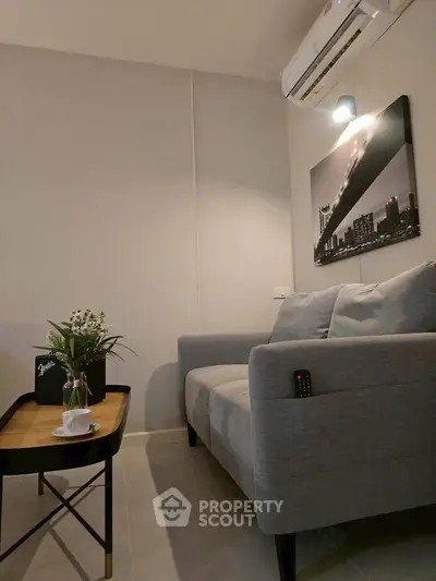 Cozy living room with modern sofa and wall art, featuring air conditioning.