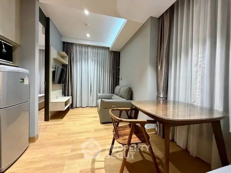 Modern living room with wooden flooring, stylish furniture, and ambient lighting.