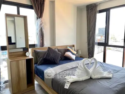Modern bedroom with large windows and stylish decor in a bright apartment.