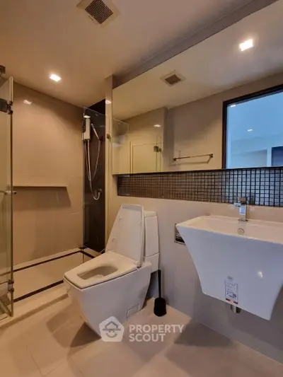 Modern bathroom with sleek fixtures and glass shower enclosure