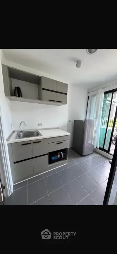 Modern kitchen with sleek cabinetry and large window for natural light
