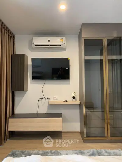 Modern bedroom with wall-mounted TV and air conditioning unit