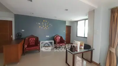 Spacious living room with elegant chairs and natural light, perfect for relaxation and entertaining.