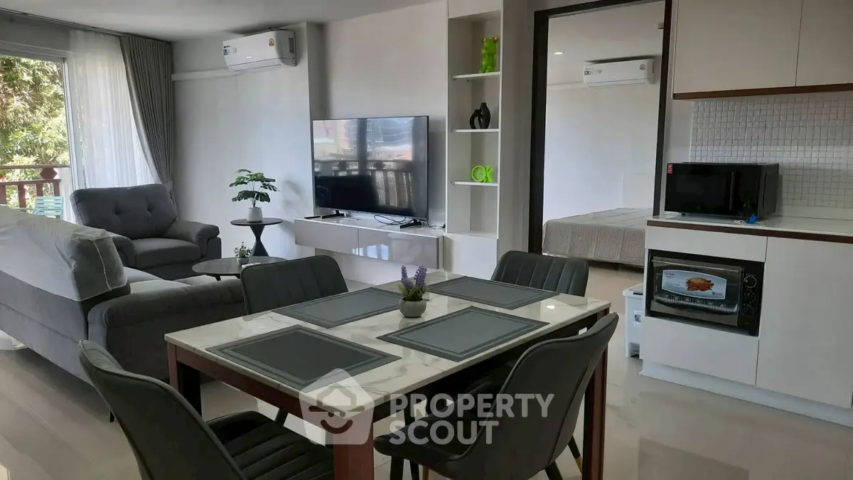Modern open-plan living room with dining area and sleek kitchen appliances