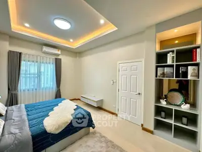 Modern bedroom with elegant lighting and built-in shelving, featuring a cozy bed and stylish decor.