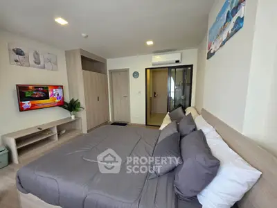 Modern bedroom with stylish decor and wall-mounted TV in a cozy apartment.