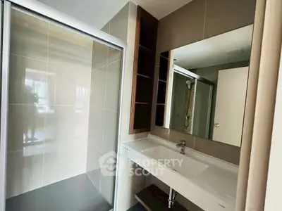 Modern bathroom with sleek design featuring a large mirror and spacious shower area.