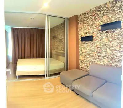 Modern bedroom with stone accent wall and cozy seating area